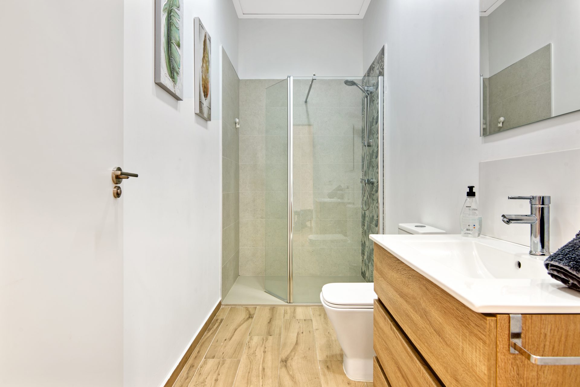 Baño de diseño con mueble de madera y ducha de lluvia