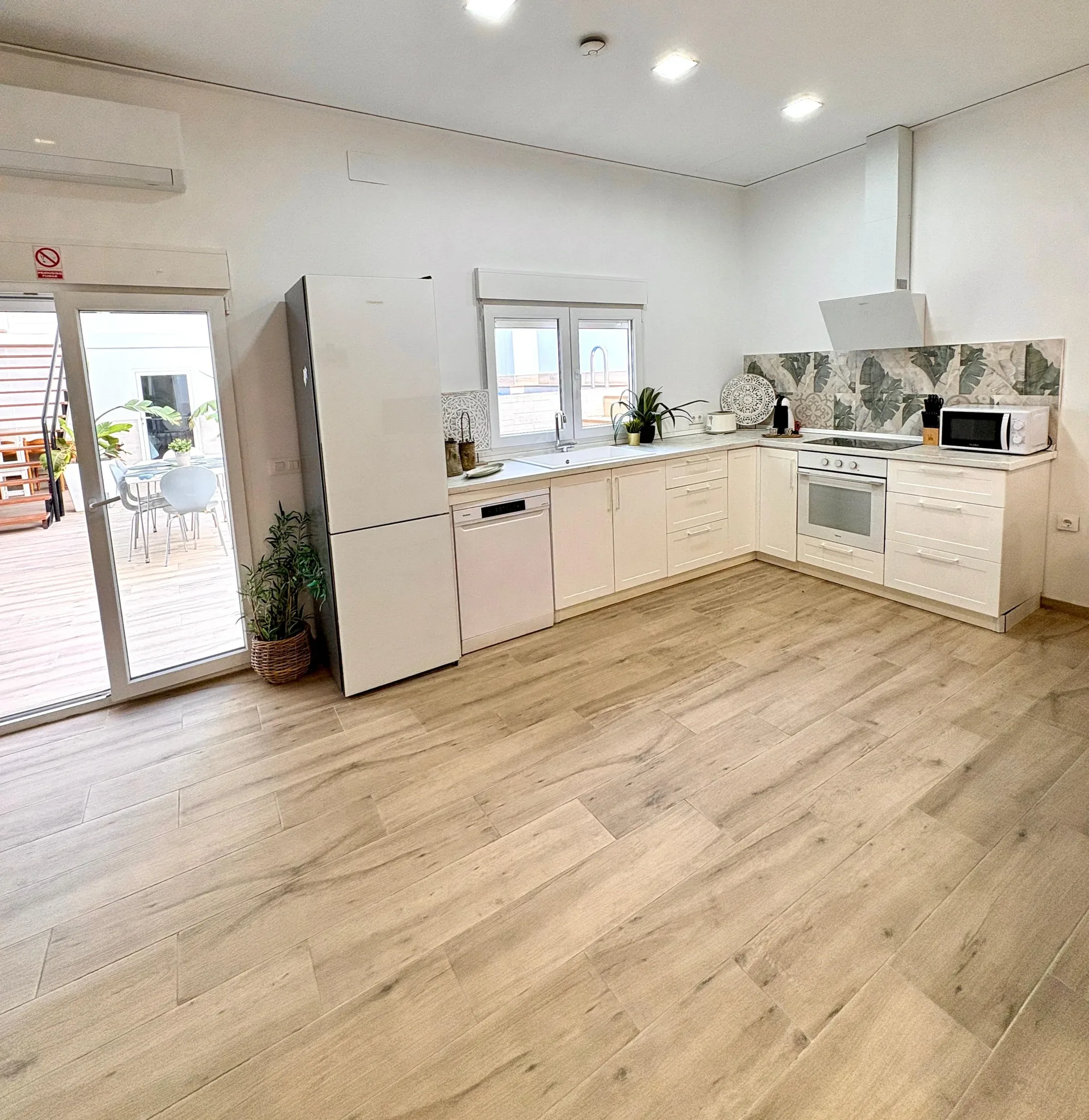 Gran comedor para 12 personas con mesa de madera y lámparas industriales — Vivienda Lope de Vega Gandía