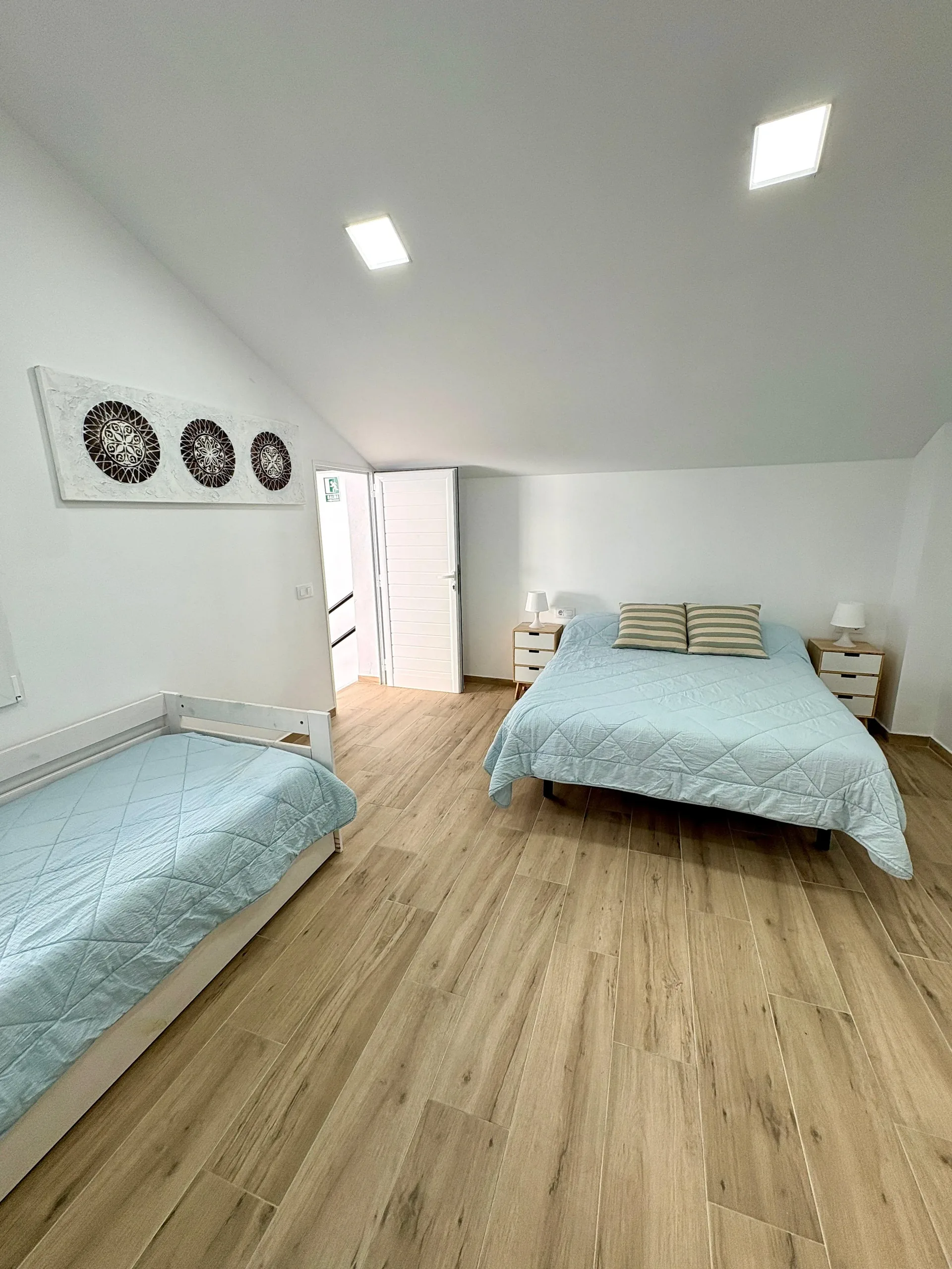 Comedor con mesa larga, sillas blancas, lámparas industriales y reloj — Vivienda Lope de Vega Gandía