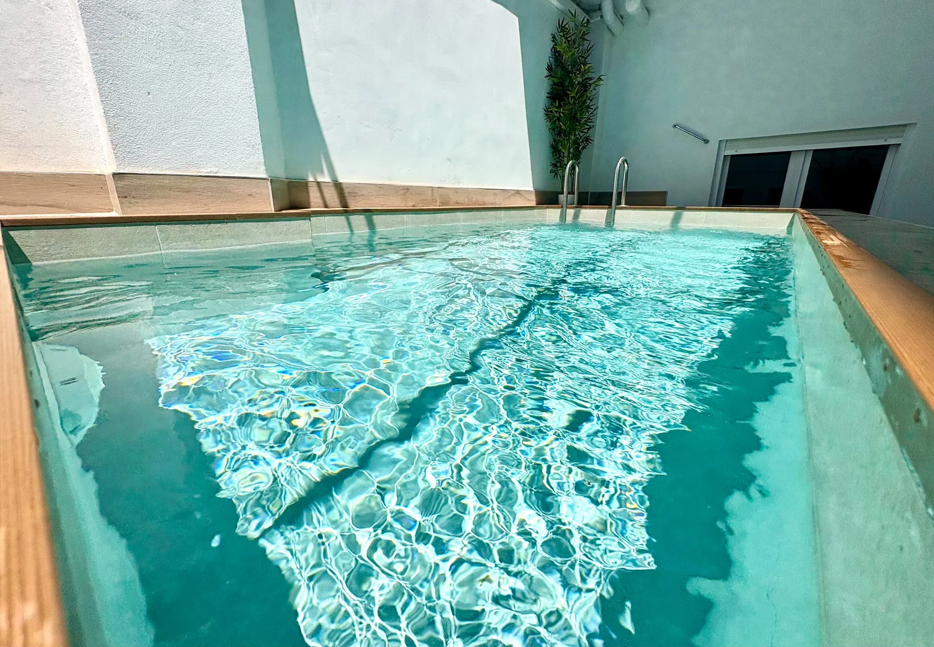 Primer plano del agua cristalina de la piscina climatizada con reflejos y luz natural — Vivienda Lope de Vega Gandía