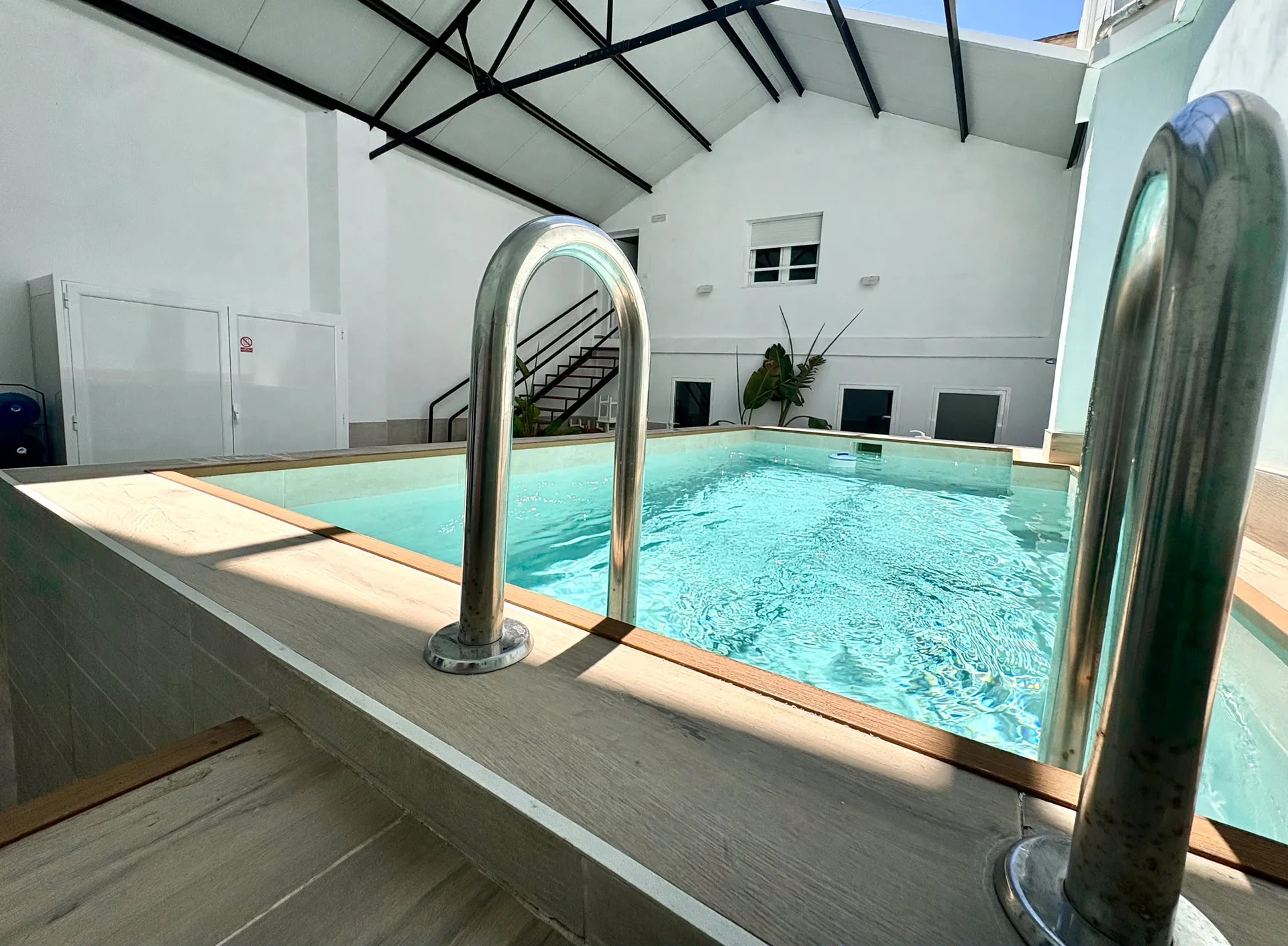 Piscina climatizada con pasamanos de acero inoxidable y lucernario industrial — Vivienda Lope de Vega Gandía