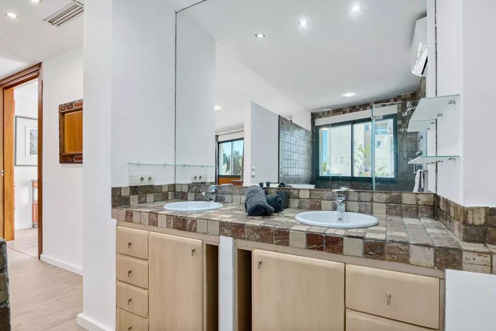 Baño con doble lavabo y encimera de azulejo artesanal