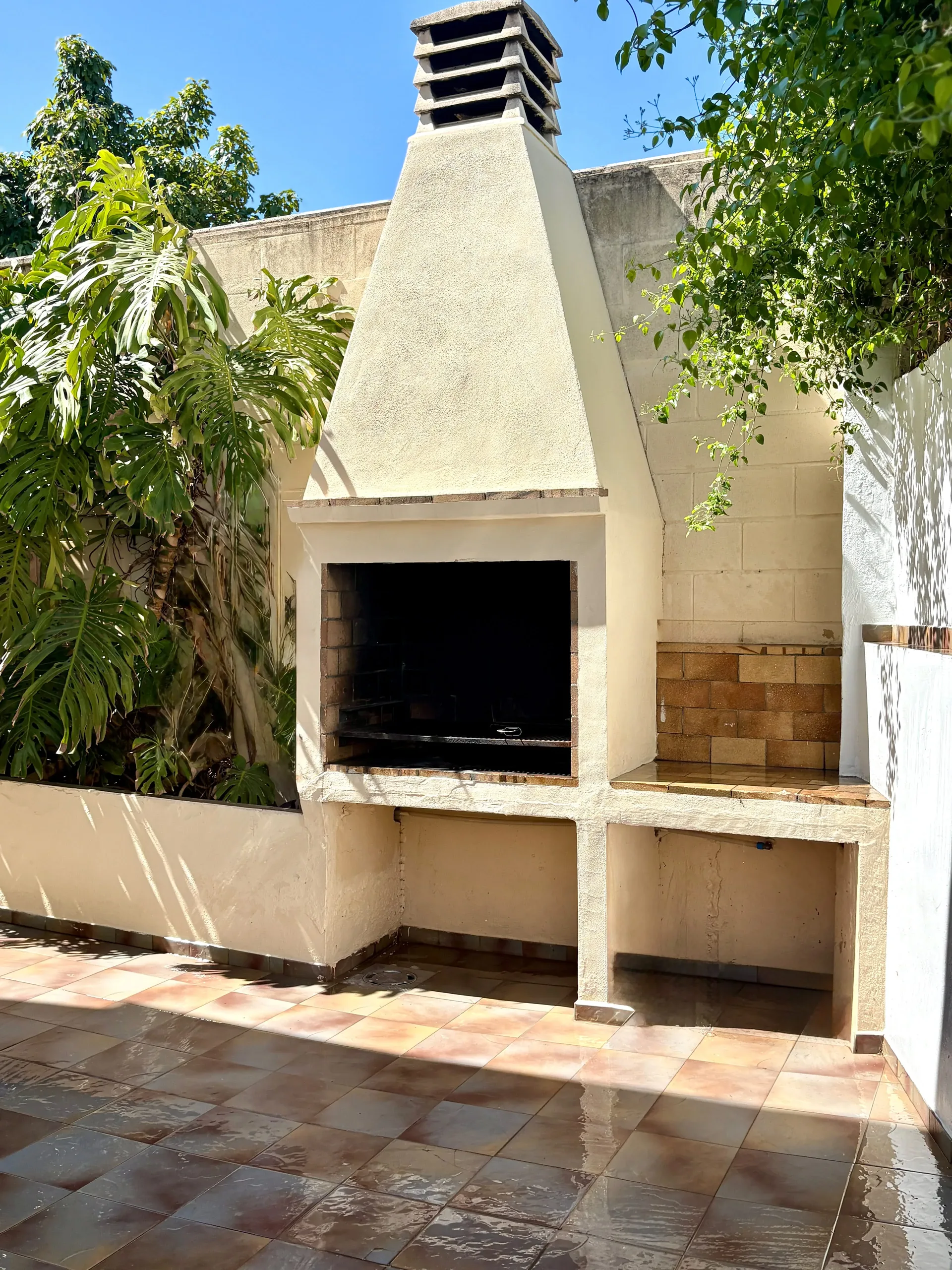 Terraza exterior del Chalet Treviso con sofá de palets, cojines y fachada de dos plantas