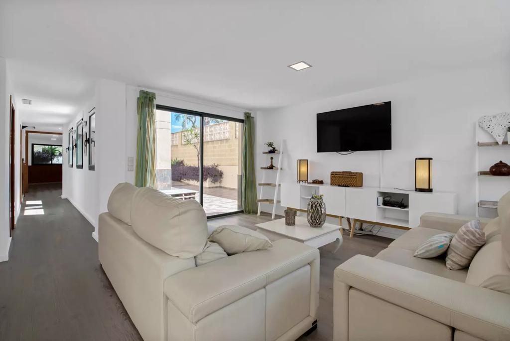 Salón principal con sofás de piel y acceso a terraza