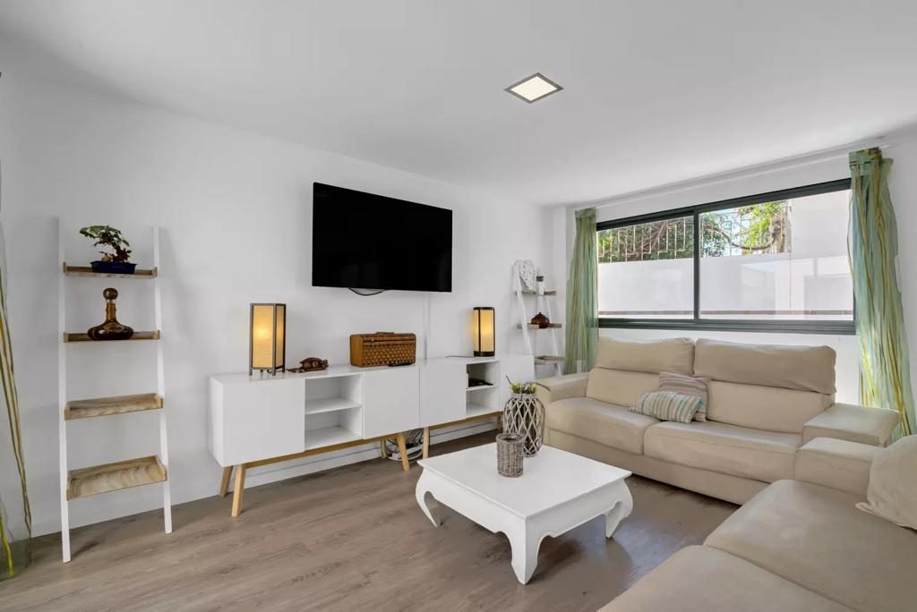 Segundo salón luminoso con TV y ventana al jardín