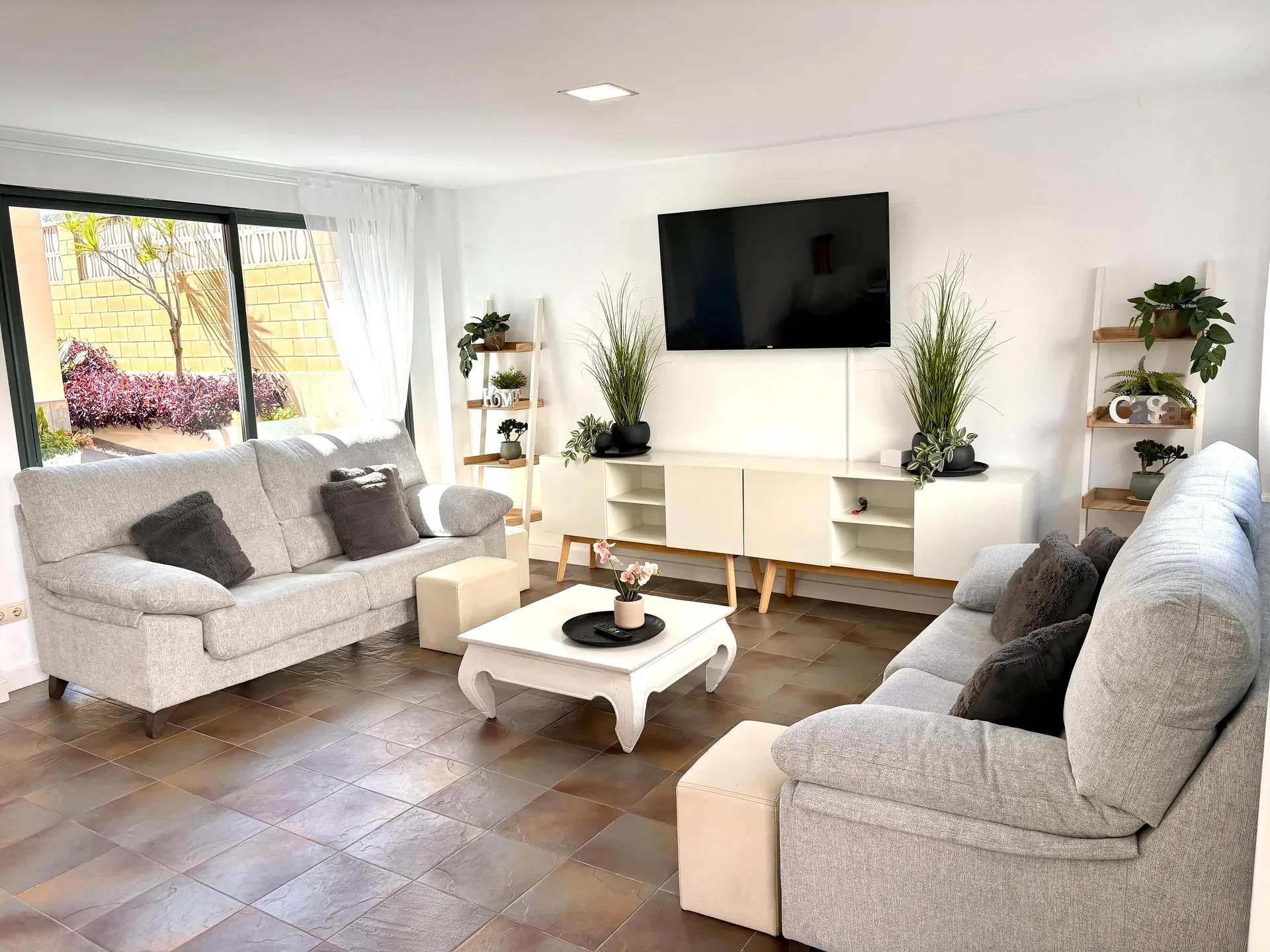 Zona de comedor pequeño con aparador de madera y aire acondicionado — Chalet Treviso Gandía
